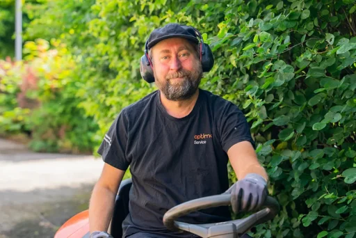 En fastighetsskötare från Optimal Service utför skötsel av utemiljö