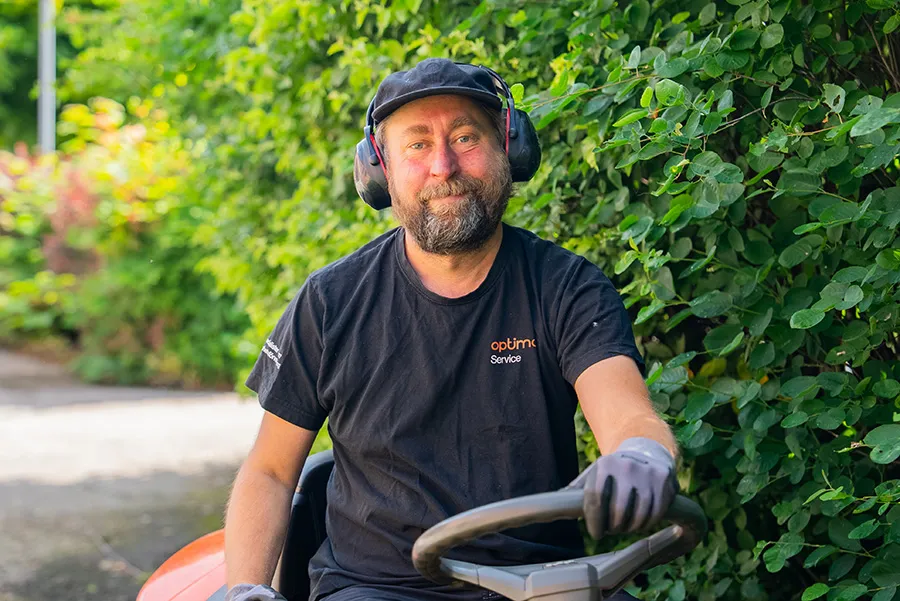 En fastighetsskötare från Optimal Service utför skötsel av utemiljö