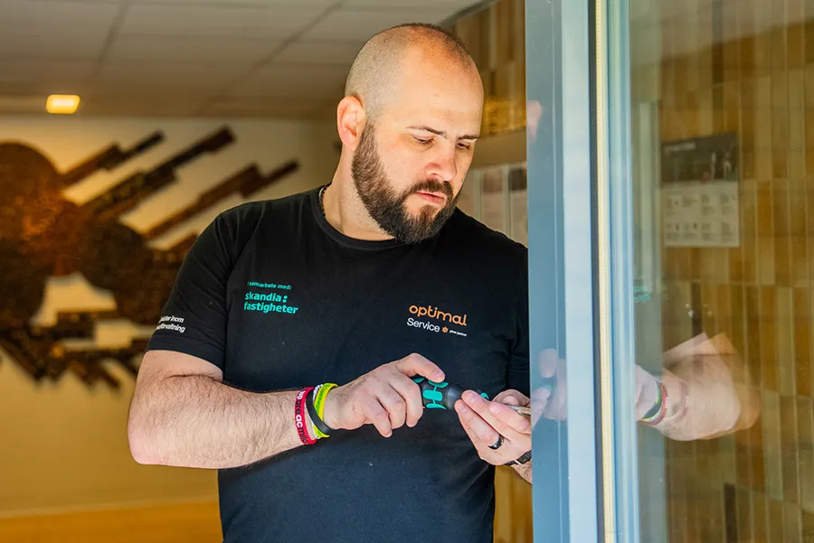 En fastighetsskötare lagar ett lås, en uppgift som ingår i fastighetsskötsel